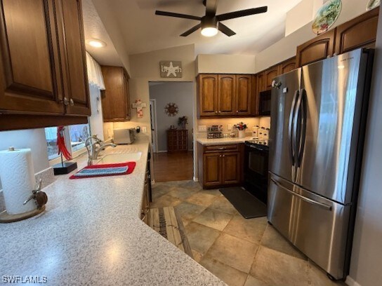 408 SE 19th Ln, Cape Coral, FL 33990 - kitchen featuring light countertops, a sink, a ceiling fan, lofted ceiling, and black appliances