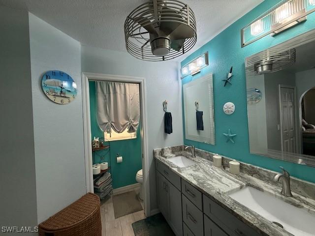 408 SE 19th Ln, Cape Coral, FL 33990 - full bath featuring toilet, wood finished floors, double vanity, and a sink