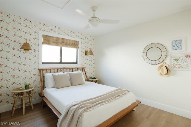 167 1st St, Bonita Springs, FL 34134 - bedroom with light wood finished floors, baseboards, wallpapered walls, and ceiling fan