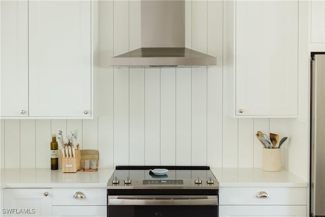 167 1st St, Bonita Springs, FL 34134 - kitchen featuring wall chimney range hood, white cabinets, light countertops, and stainless steel appliances