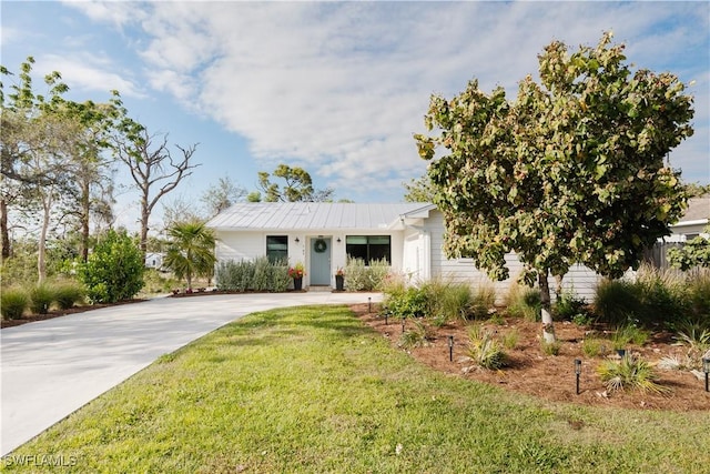 167 1st St, Bonita Springs, FL 34134 - view of front of home featuring a front yard, driveway, and metal roof