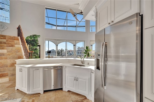 159 Geranium Ct, Marco Island, FL 34145 - kitchen with appliances with stainless steel finishes, white cabinets, a peninsula, crown molding, and light countertops