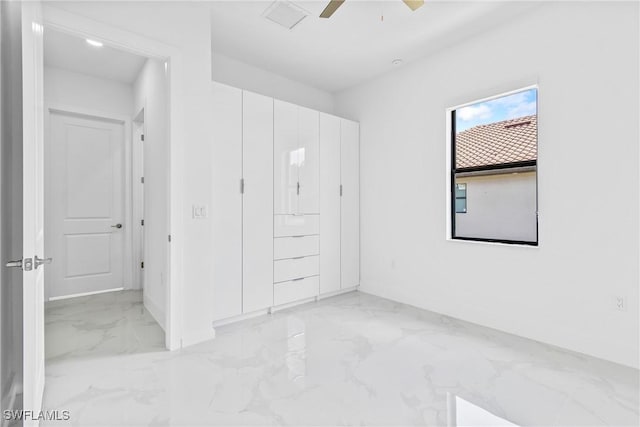 unfurnished bedroom with baseboards, ceiling fan, and marble finish floor