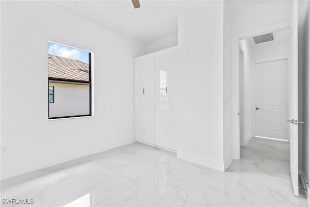unfurnished room featuring baseboards, marble finish floor, and visible vents