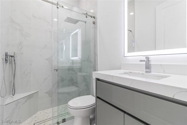 bathroom with a marble finish shower, vanity, and toilet