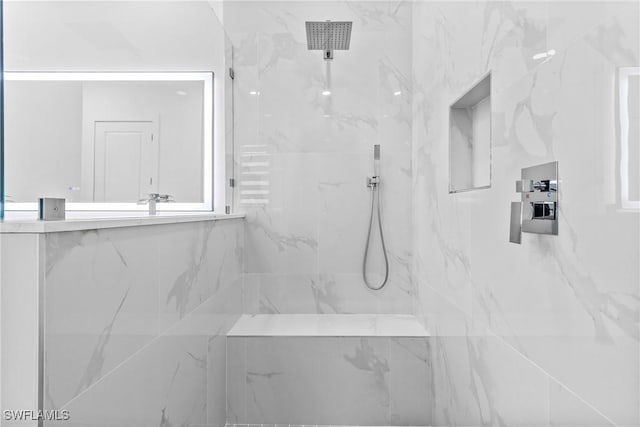 bathroom featuring a marble finish shower