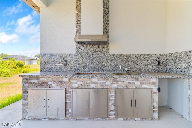 view of patio with a garage, a sink, and an outdoor kitchen