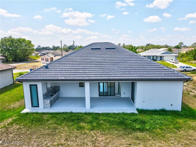 back of property featuring a residential view, stucco siding, a yard, and a patio area