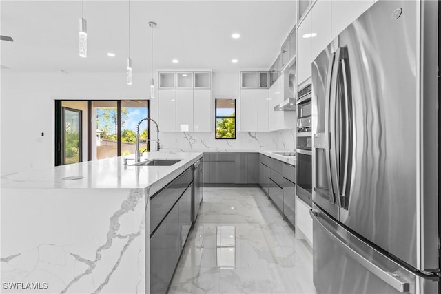 kitchen featuring a sink, appliances with stainless steel finishes, modern cabinets, and marble finish floor