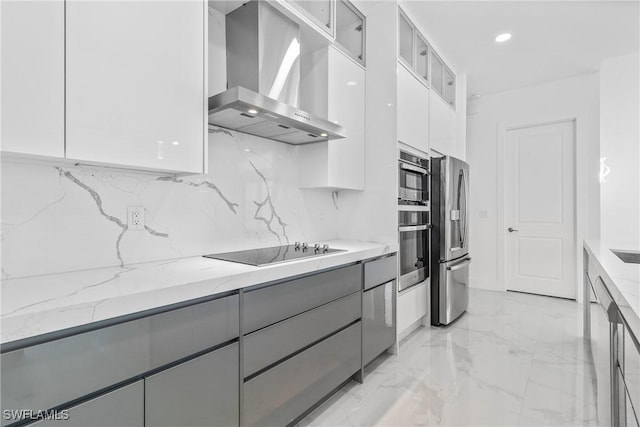 kitchen featuring wall chimney range hood, stainless steel refrigerator with ice dispenser, modern cabinets, gray cabinetry, and black electric stovetop