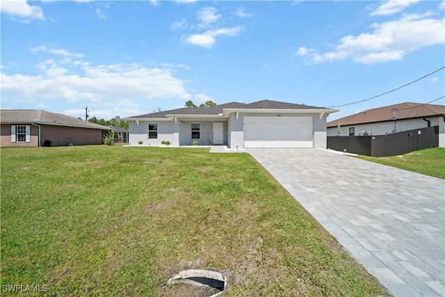 view of front of house with fence, decorative driveway, an attached garage, a front lawn, and stucco siding