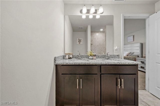 bathroom with double vanity, a sink, ensuite bath, and visible vents