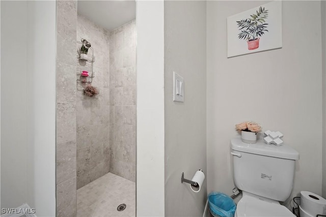 bathroom featuring a tile shower and toilet