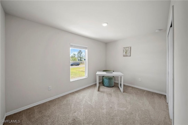 carpeted empty room featuring baseboards