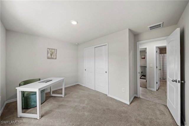unfurnished office with carpet flooring, baseboards, and visible vents
