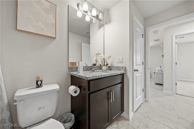 bathroom with tile patterned floors, toilet, vanity, baseboards, and visible vents