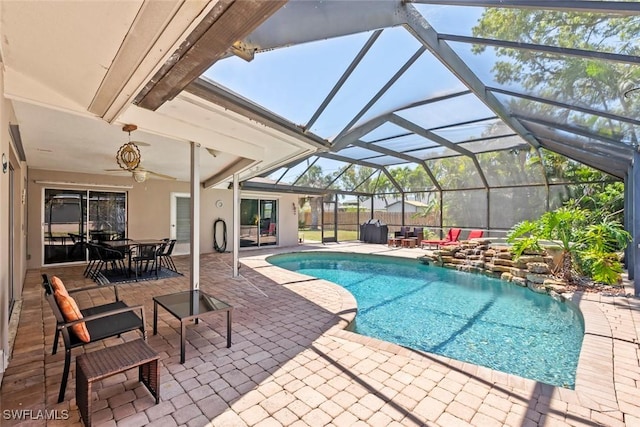 outdoor pool with a patio area, outdoor dining area, glass enclosure, and a ceiling fan