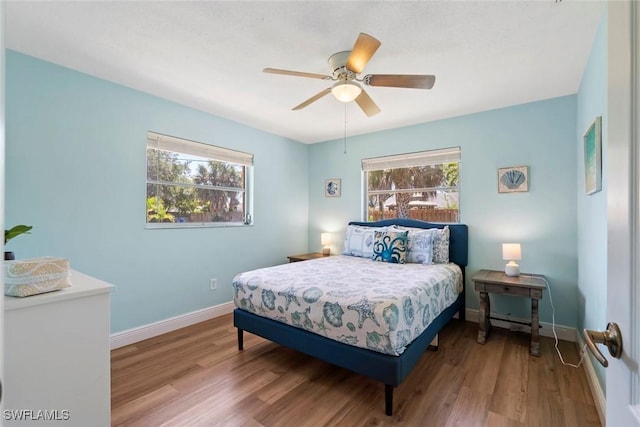 bedroom with baseboards, ceiling fan, and wood finished floors