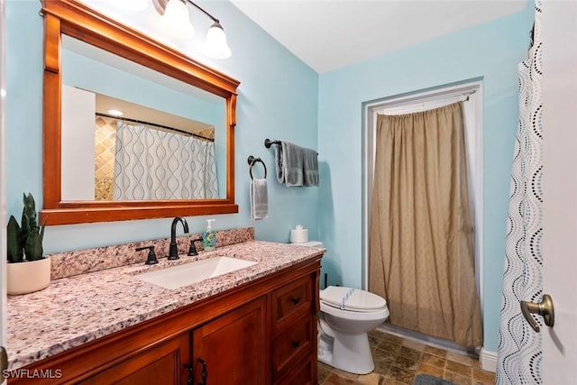 full bathroom featuring toilet, vanity, and stone finish flooring