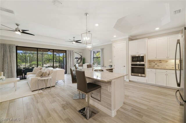28091 Foxrock Ct, Bonita Springs, FL 34135 - kitchen with visible vents, a sink, open floor plan, appliances with stainless steel finishes, and light stone countertops