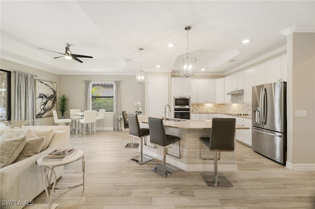 28091 Foxrock Ct, Bonita Springs, FL 34135 - kitchen featuring open floor plan, backsplash, under cabinet range hood, a kitchen bar, and stainless steel appliances