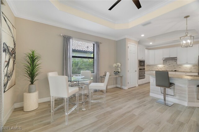 28091 Foxrock Ct, Bonita Springs, FL 34135 - dining room with light wood-style floors, ceiling fan with notable chandelier, ornamental molding, and a raised ceiling