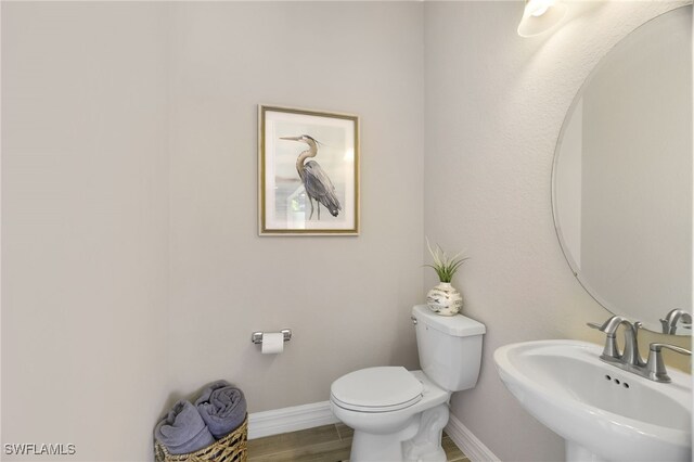 28091 Foxrock Ct, Bonita Springs, FL 34135 - bathroom with baseboards, a sink, toilet, and wood finished floors