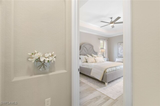 28091 Foxrock Ct, Bonita Springs, FL 34135 - bedroom featuring crown molding, a tray ceiling, ceiling fan, and wood finished floors