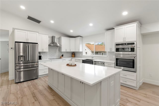 1020 19th St SW, Naples, FL 34117 - kitchen featuring appliances with stainless steel finishes, wall chimney exhaust hood, a sink, a center island, and tasteful backsplash