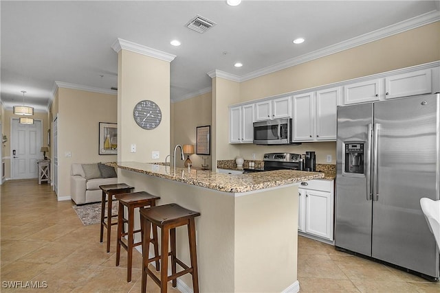 9815 Giaveno Ct Unit 1245, Naples, FL 34113 - kitchen with appliances with stainless steel finishes, light stone counters, a breakfast bar, recessed lighting, and white cabinetry