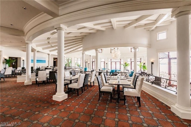 dining area featuring beamed ceiling, decorative columns, carpet flooring, and plenty of natural light