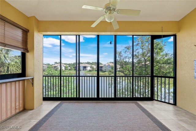 unfurnished sunroom with a water view and a residential view