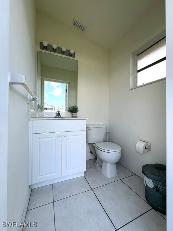 940 SE 20th Ct, Cape Coral, FL 33990 - half bathroom with toilet, vanity, tile patterned floors, and visible vents