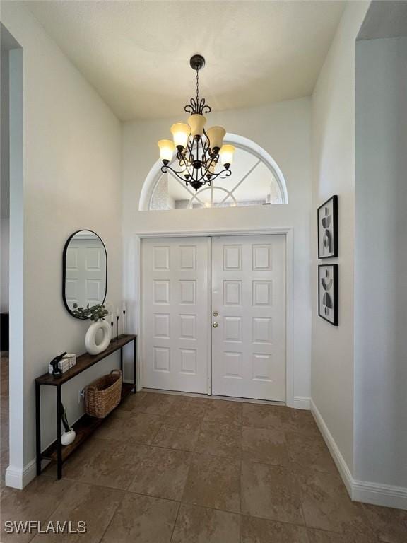 940 SE 20th Ct, Cape Coral, FL 33990 - foyer featuring baseboards and a notable chandelier