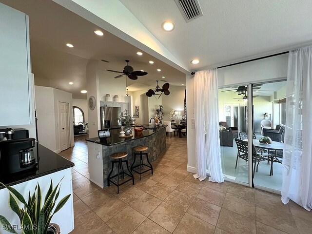 940 SE 20th Ct, Cape Coral, FL 33990 - kitchen with stainless steel fridge with ice dispenser, lofted ceiling, ceiling fan, and dark countertops