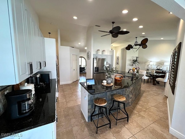 940 SE 20th Ct, Cape Coral, FL 33990 - kitchen featuring a kitchen breakfast bar, stainless steel refrigerator with ice dispenser, a sink, ceiling fan, and white cabinets