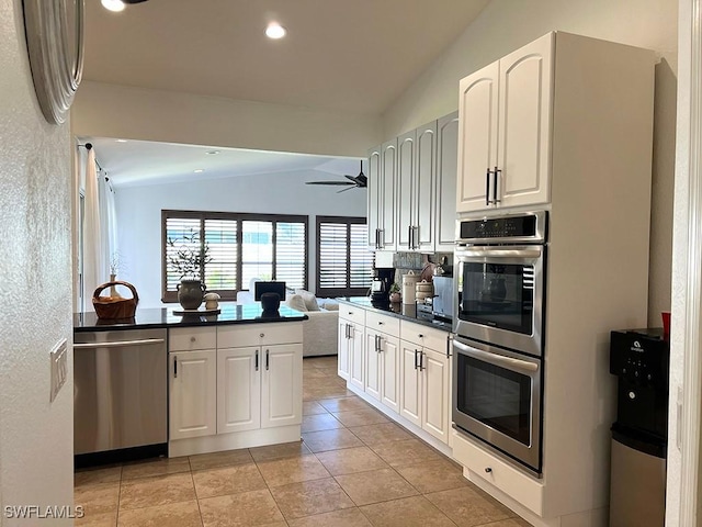 940 SE 20th Ct, Cape Coral, FL 33990 - kitchen with vaulted ceiling, white cabinetry, appliances with stainless steel finishes, open floor plan, and dark countertops