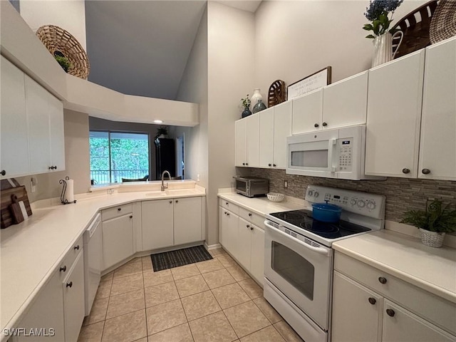 8125 Celeste Dr Unit 5213, Naples, FL 34113 - kitchen with high vaulted ceiling, a sink, backsplash, light tile patterned floors, and white appliances
