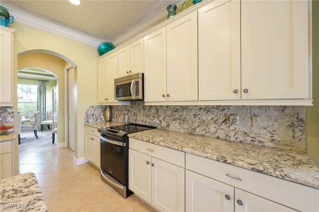 11619 Giulia Dr, Fort Myers, FL 33913 - kitchen featuring crown molding, stainless steel microwave, arched walkways, electric stove, and backsplash