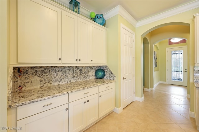 11619 Giulia Dr, Fort Myers, FL 33913 - kitchen with arched walkways, decorative backsplash, crown molding, and light tile patterned floors