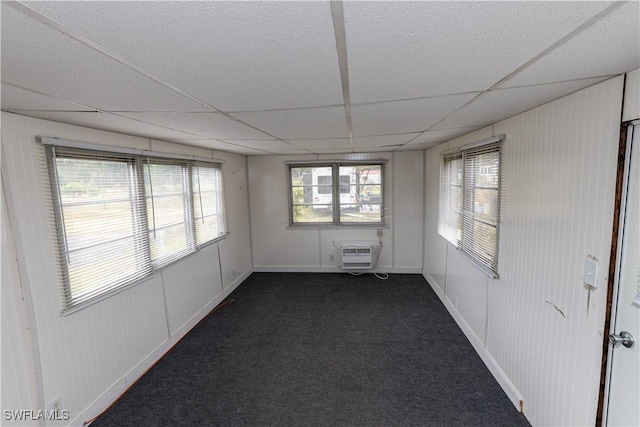 17841 Palm Creek Dr, North Fort Myers, FL 33917 - empty room featuring dark colored carpet, a drop ceiling, and a wall mounted air conditioner