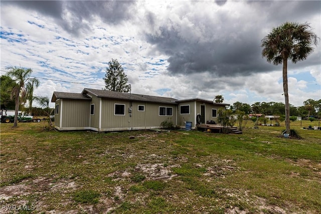 17841 Palm Creek Dr, North Fort Myers, FL 33917 - back of house with a lawn and a deck