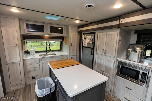 17841 Palm Creek Dr, North Fort Myers, FL 33917 - kitchen with a sink, light countertops, stainless steel microwave, visible vents, and freestanding refrigerator
