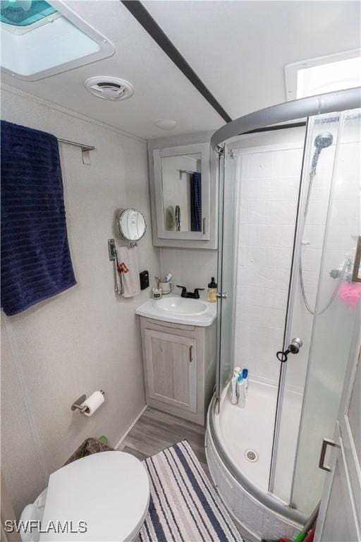 17841 Palm Creek Dr, North Fort Myers, FL 33917 - bathroom with toilet, a stall shower, visible vents, wood finished floors, and vanity