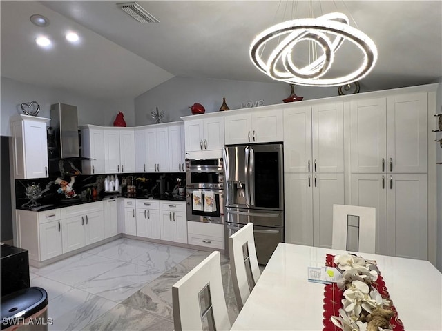 kitchen with marble finish floor, visible vents, vaulted ceiling, white cabinetry, and appliances with stainless steel finishes