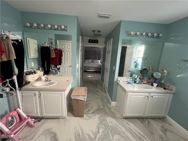 bathroom featuring marble finish floor, visible vents, and a sink