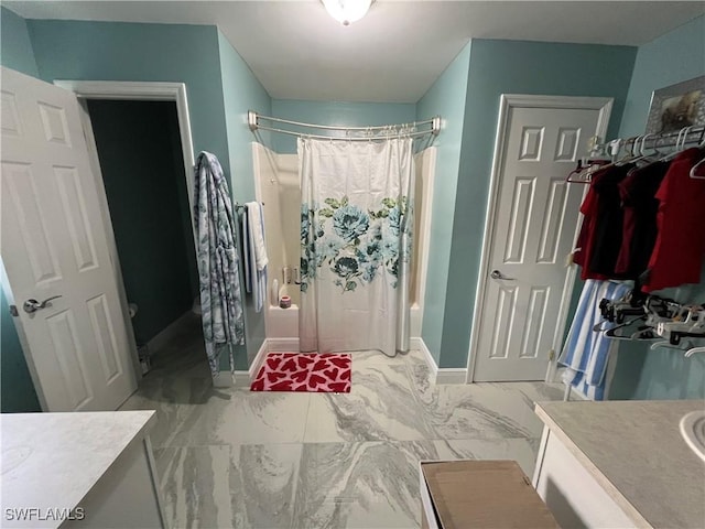 full bathroom with vanity, a shower with shower curtain, baseboards, and marble finish floor