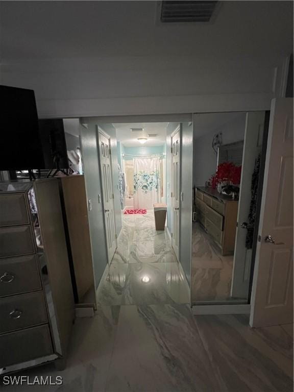 corridor featuring marble finish floor and visible vents