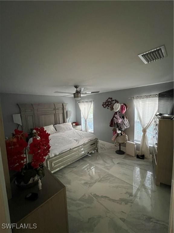 bedroom featuring ceiling fan, marble finish floor, and visible vents