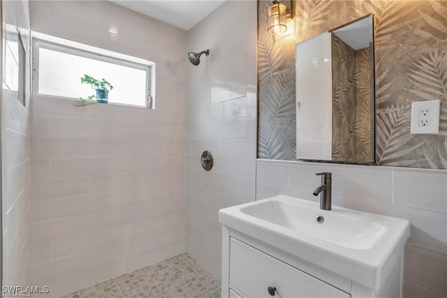 full bath featuring tile walls, vanity, and tiled shower